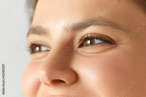 Close-up image of female face, eyes, nose. Woman with well-kept, smooth, glowing skin. Concept of natural beauty, cosmetology and dermatology, skincare, cosmetics, ad