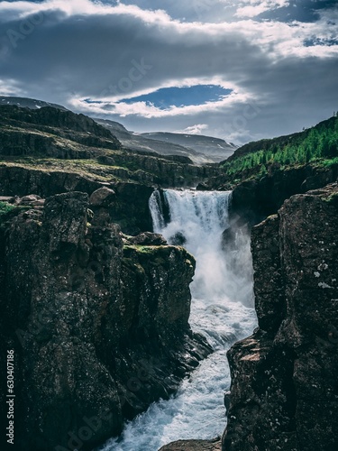 Vertical shot of a picturesque rocky waterfall in the East Fjords, Iceland
