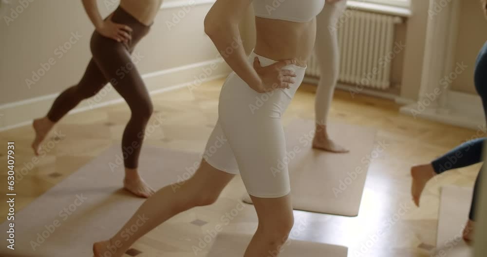 Millenial women do exercises in a yoga studio, 4k