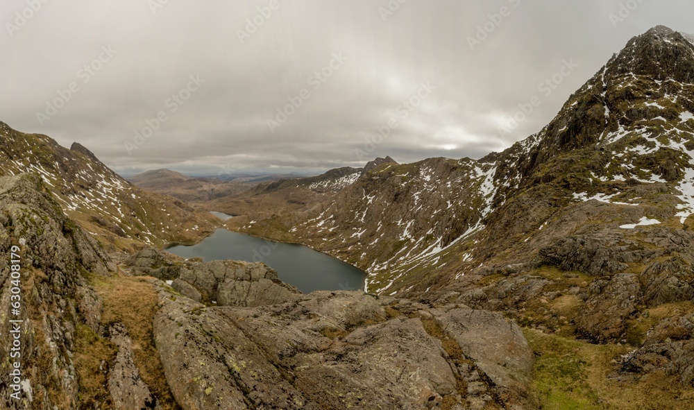 View from the ascent to the summit of Yr Wyddfa in Snowdonia, Wales against a clouded sky View from the ascent to the summit of Yr Wyddfa in Snowdonia, Wales against a clouded sky