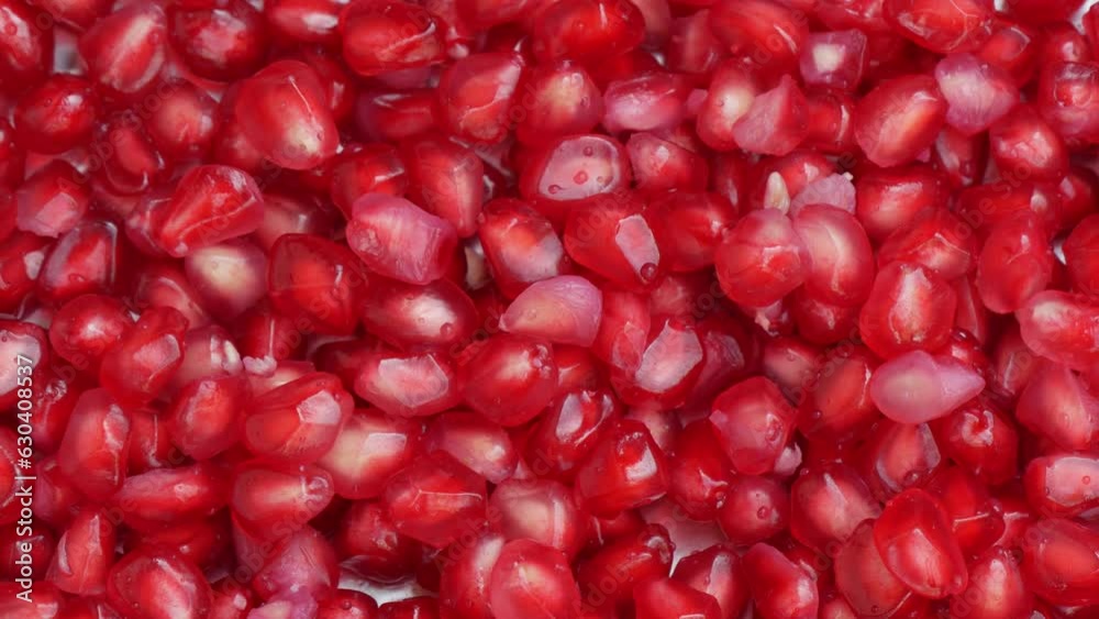 Pomegranate Grains rolls down on Pomegranate Fruits background. Pomegranate Grains rolls down on Pomegranate Fruits background.