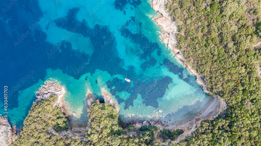 Top picture of  with a turquoise blue lagoon at Mediterranean, some boats and a lot of green trees, and a lake on the top of the picture. Aerial view of the famous  island and Blue lagoon.