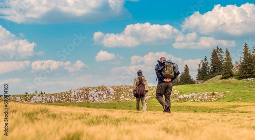 Mountaineers walking on a mountain meadow - Sport and recreation concept