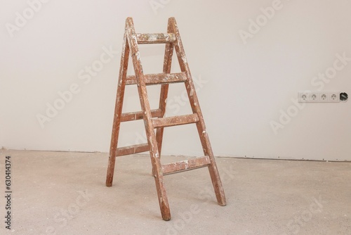 Valokuva Vintage wooden ladder against a smooth white wall in an unoccupied room