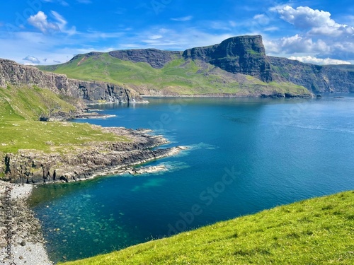 Idyllic grassy field with a sparkling blue lake visible in the distance