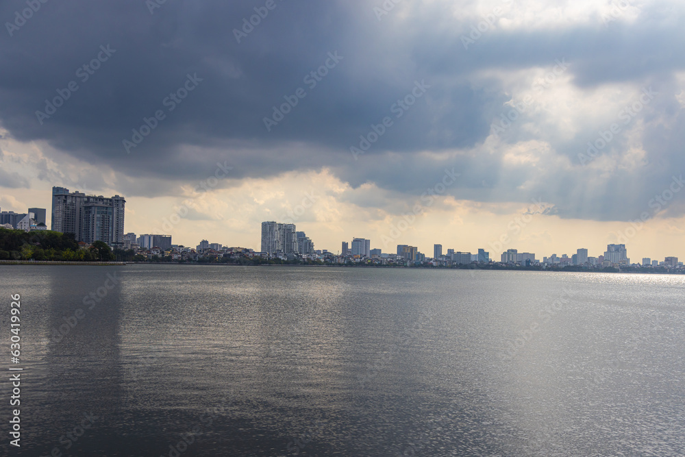 Hanoi, Vietnam - July 10, 2023: Gazing across West Lake, reflection of the sky on its waters, stands the Tran Quoc Pagoda, a captivating tourist attraction and destination of sublime beauty