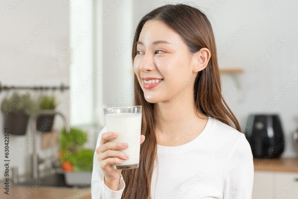 Health care, pretty asian young woman, girl drinking a glass of white fresh, dairy milk for calcium, vitamin wholesome good nutrition in morning at kitchen home. lifestyle, product healthy people. Health care, pretty asian young woman, girl drinking a glass of white fresh, dairy milk for calcium, vitamin wholesome good nutrition in morning at kitchen home. lifestyle, product healthy people.
