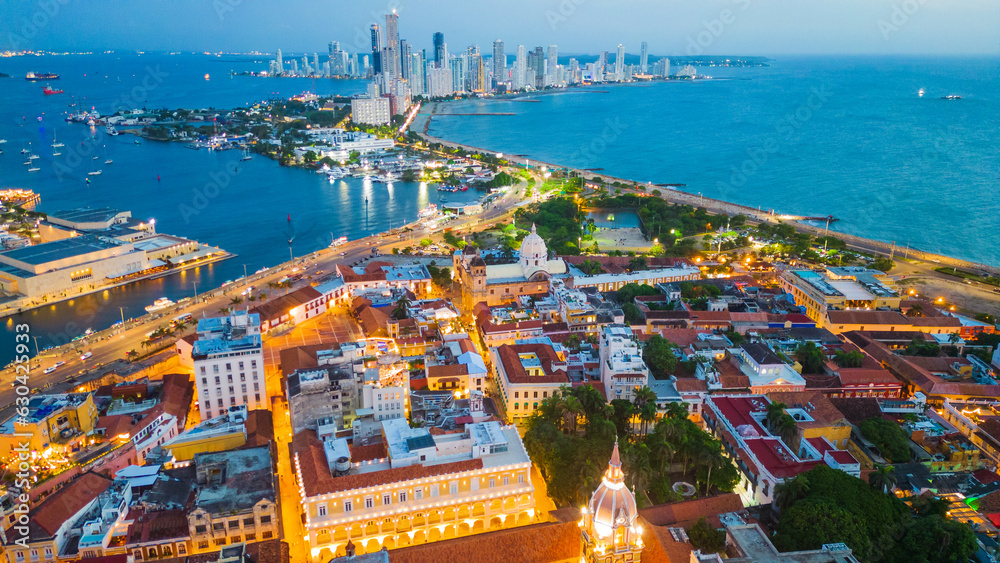 drone fly above Cartagena walled city old historical downtown with modern skyline at distance of Bocagrande in contrast with old church cusp