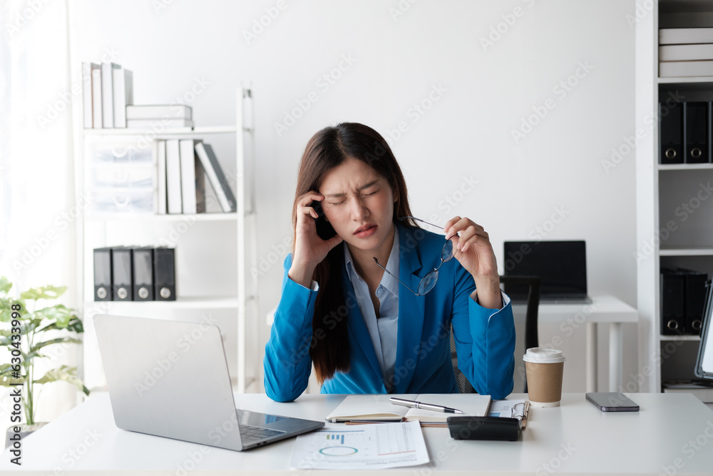 Tired and stressful Asian office worker having a hard time trying to focus on her work, feeling tried after working a long day. Tired and stressful Asian office worker having a hard time trying to focus on her work, feeling tried after working a long day.