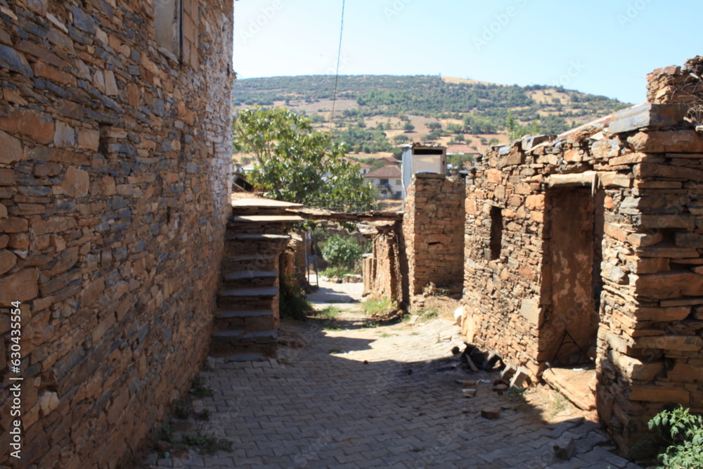 narrow street of abandoned houses built with stones