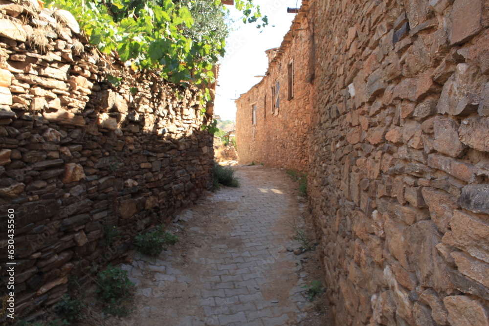 narrow street of abandoned houses built with stones