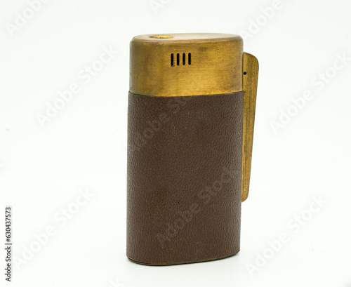 Fotografie Antique brass and leather cigarette lighter with tarnish and patina isolated on a white background