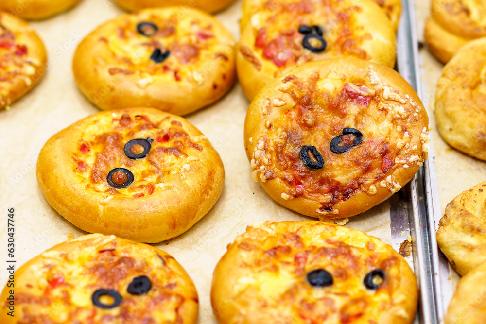 Mini pizza. Appetizing pastries. Fast food. Snack from the bakery for a break. Background with selective focus Mini pizza. Appetizing pastries. Fast food. Snack from the bakery for a break. Background with selective focus