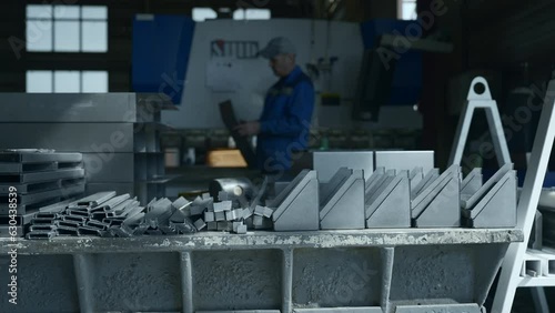 Metal parts on factory table with working assembler. Creative. Worker assembles factory machines with metal parts. Various metal parts for assembling factory machines