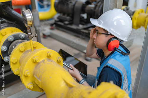 Maintenance technician at a heating plant,Petrochemical workers supervise the operation of gas and oil pipelines in the factory,Engineers put hearing protector At room with many pipes