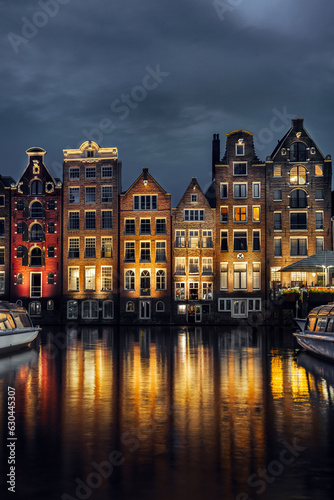 Night dancing houses at Amsterdam canal Damrak, Holland, Netherlands.