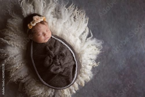 Photographie portrait of beautiful newborn baby girl sleeping wrapped on wool with floral hea