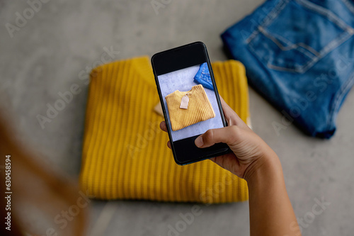 Woman taking photo of shirt on smartphone