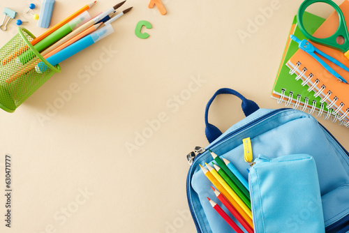 Preparing for elementary school start. Top view composition of school supplies, blue schoolbag, colorful letters on pastel beige background with empty space for advert or message