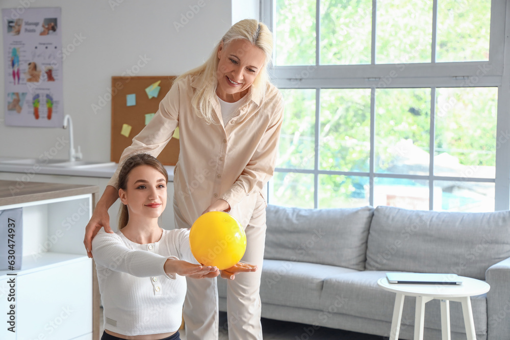 Young woman training with ball and female physiotherapist in rehabilitation center Young woman training with ball and female physiotherapist in rehabilitation center