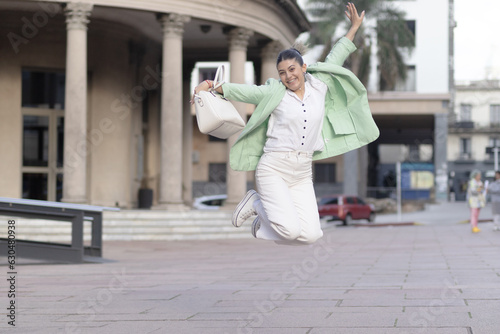 Young woman dressed up girl jumping for happiness on the street.