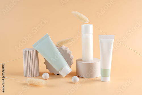 Group of white and green blank, unbranded cosmetic cream jars and tubes on beige background on concrete podiums. Skin care product presentation. Elegant mockup. Skincare, beauty and spa.