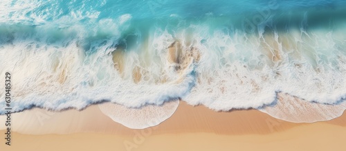 shows an aerial view of a sandy beach with clear light blue water  waves  and sunlight. It represents a summer vacation background with space for text and conveys a natural beauty spa concept.