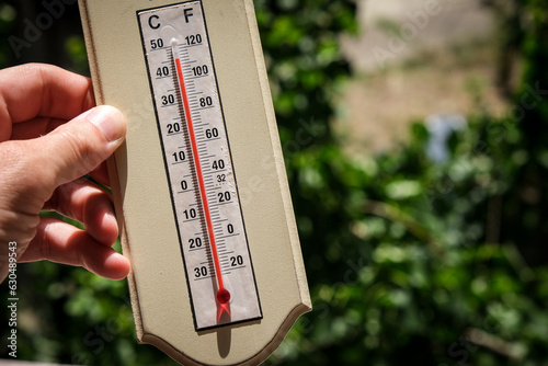 Ice cubes melting in direct sun next to a home thermometer showing over 40 degrees Celsius during a heat wave