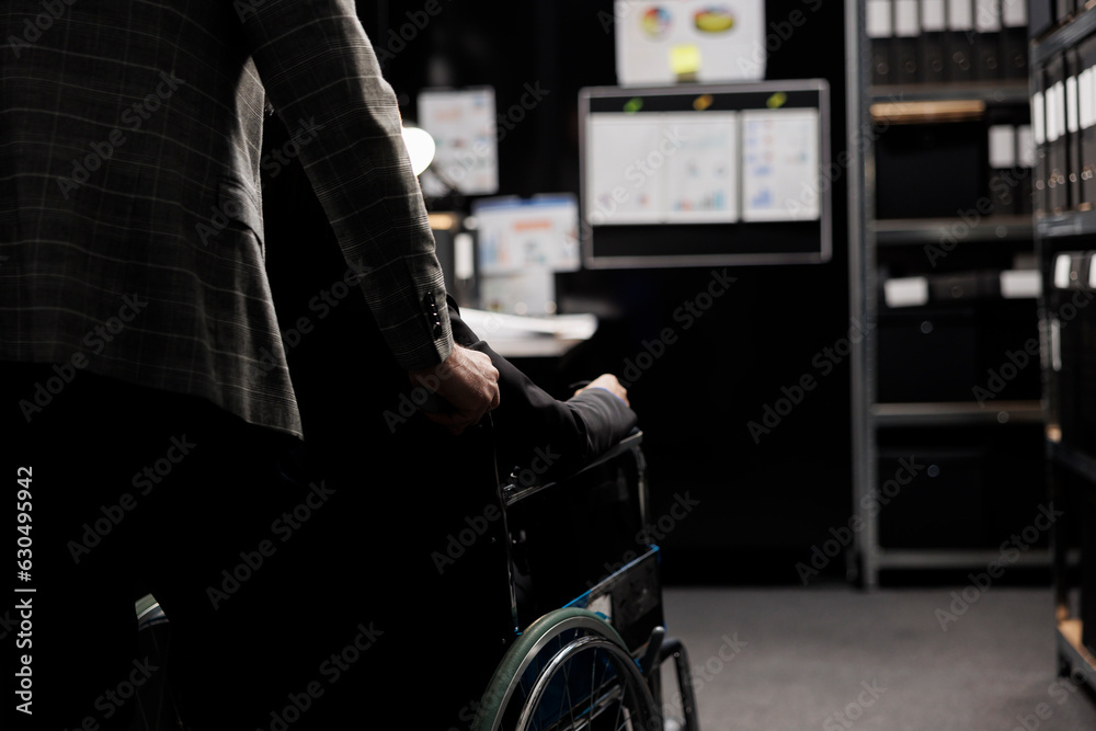 Paralyzed private detective wheelchair user and assisting coworker in criminal cases archive room. Investigator with paraplegia surrounded by criminology folders on cabinet shelves