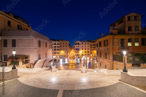 The Spanish steps with Fountain della Barcaccia at Piazza di Spagna square illuminated before sunrise, Rome, Italy