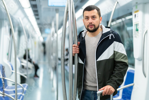 Portrait of male passenger with luggage in a subway car