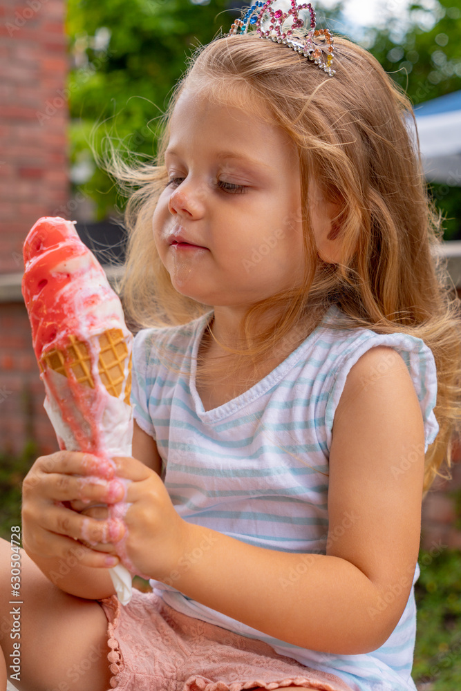a little girl enjoys eating a large strawberry vanilla ice cream in the park on a bench a little girl enjoys eating a large strawberry vanilla ice cream in the park on a bench