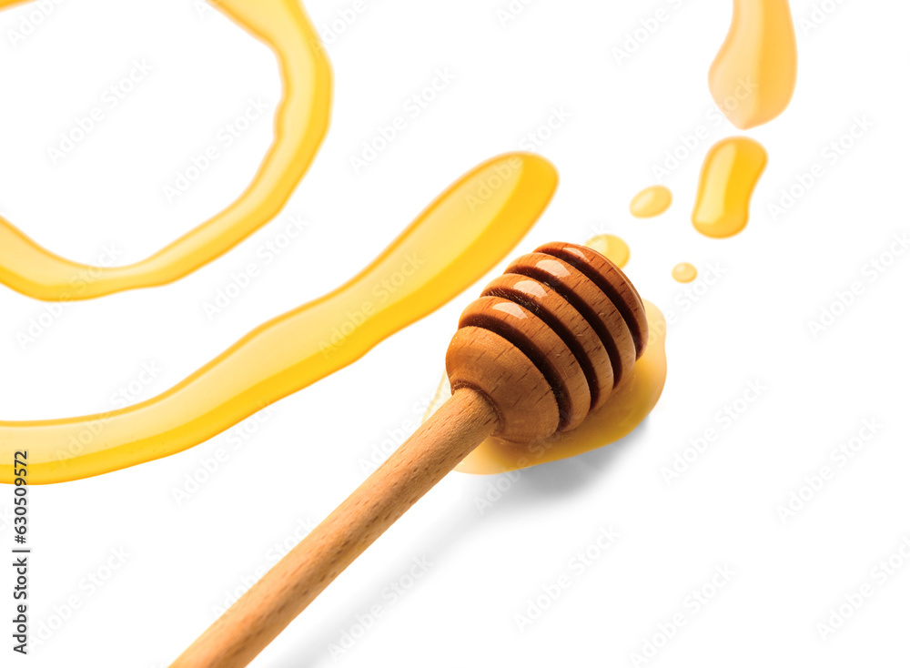 dipper for honey lies in liquid honey on a white background. dipper for honey lies in liquid honey on a white background.