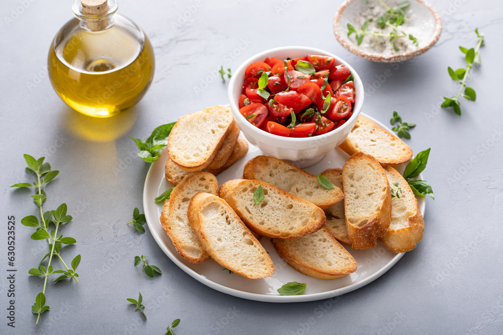 Making tomato basil bruschetta with toasted baguette and herbs Making tomato basil bruschetta with toasted baguette and herbs