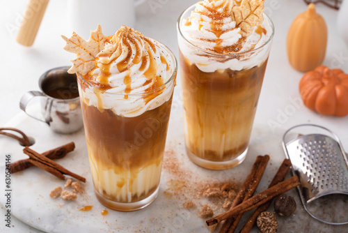 Fototapeta Pumpkin caramel iced latte with whipped cream and caramel syrup