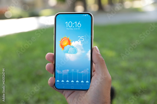 Man checking weather using app on smartphone outdoors, closeup. Data and illustration of sun with cloud on screen