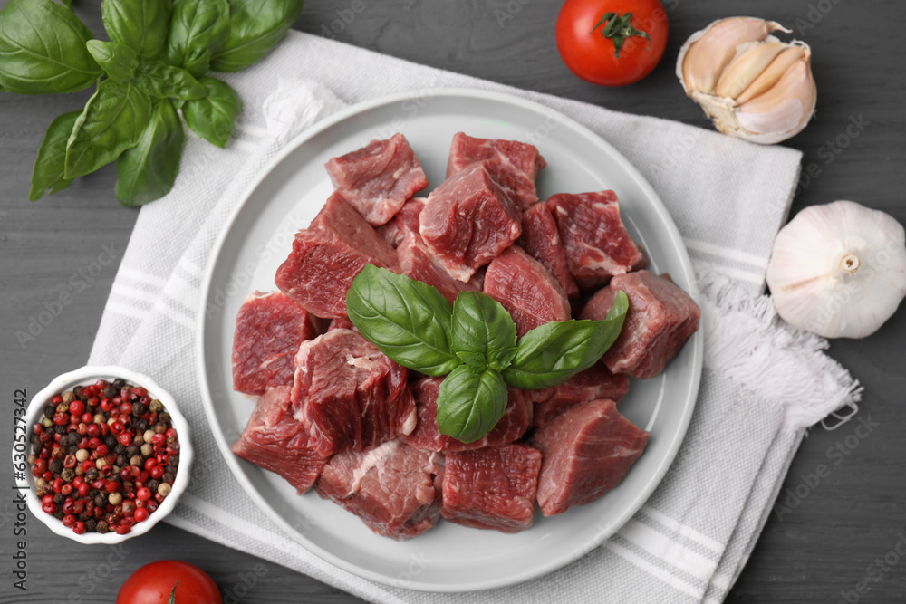 Flat lay composition with cut fresh beef meat on grey wooden table