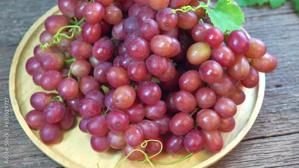 Sweet Red Grape fruit in wooden basket over wooden background, Red Grape over wooden background. Sweet Red Grape fruit in wooden basket over wooden background, Red Grape over wooden background.
