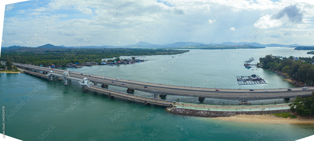 .Aerial view beautiful Sarasin bridge on the blue sea..Sarasin bridge is important route connecting by land..Scene of white cloud in blue sky and green sea..the bridge connect Phuket to Phang Nga..