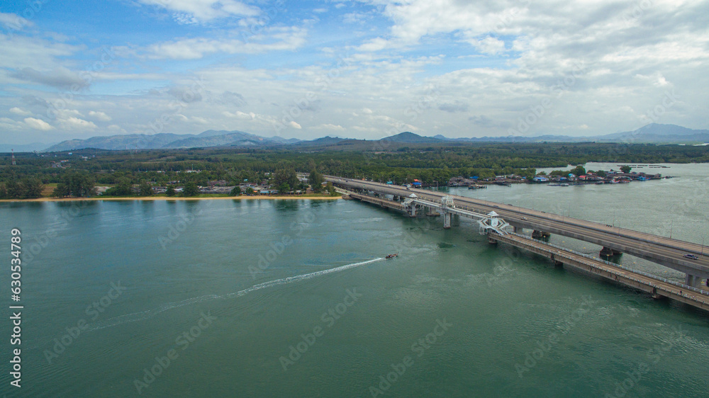 .Aerial view beautiful Sarasin bridge on the blue sea..Sarasin bridge is important route connecting by land..Scene of white cloud in blue sky and green sea..the bridge connect Phuket to Phang Nga..