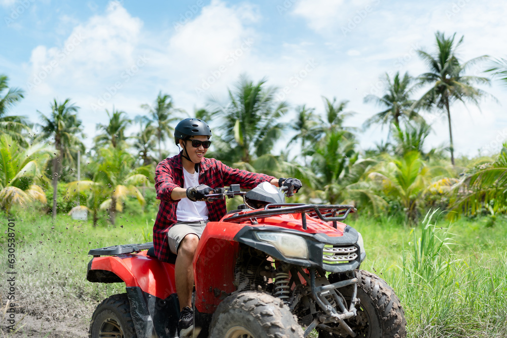 Quad bike in dust cloud, sand quarry on background. ATV Rider in the action. Quad bike in dust cloud, sand quarry on background. ATV Rider in the action.