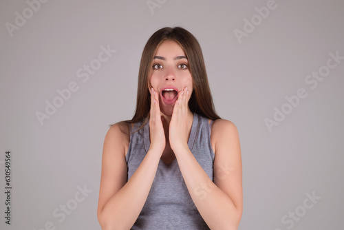 Close up photo of impressed woman isolated over studio background. Portrait of an excited young girl looking in excitement. Young woman shocked with surprise expression, amazed and excited face.