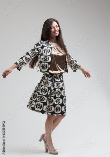 Long-haired model spins in silver-beige outfit