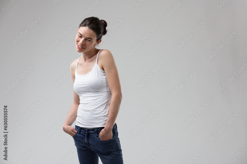 Young woman coyly poses in jeans Young woman coyly poses in jeans