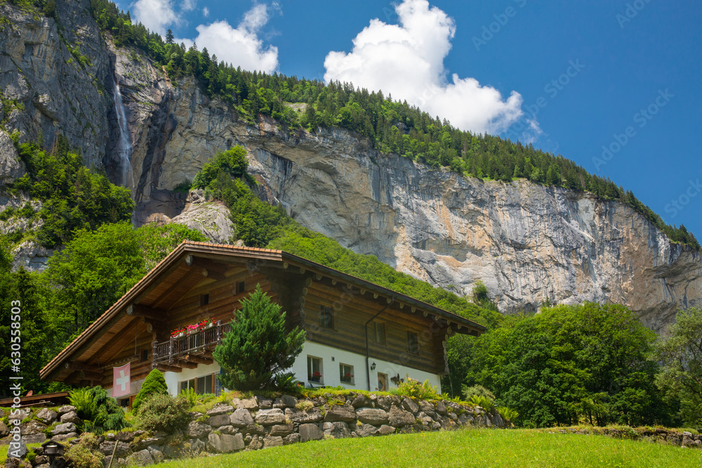 A beautiful Swiss chalet with cliff and waterfall in the background in Lauterbrunnen, Switzerland
A beautiful Swiss chalet with cliff and waterfall in the background in Lauterbrunnen, Switzerland
