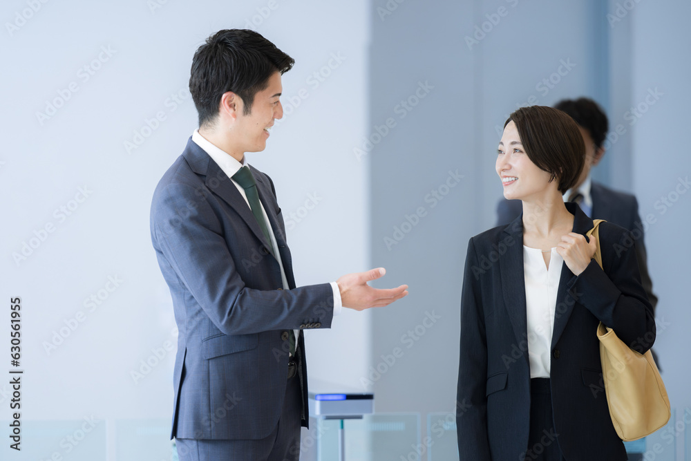 Businessman smiling and talking with colleagues in a clean office, staring at each other.