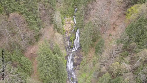 Wide aerial view of waterfall in green forest. Drone over Rausor Waterfall in Romania  and surrounding woodland landscape. photo