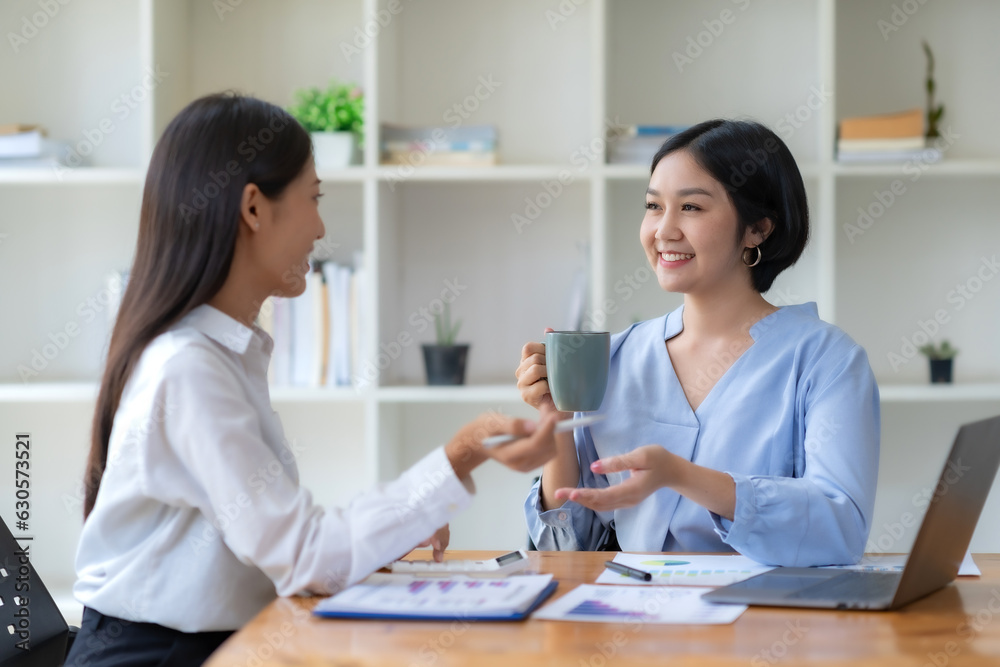 Two beautiful young Asian businesswoman in the conversation, exchanging ideas presentation analyze plan marketing and investment. Two beautiful young Asian businesswoman in the conversation, exchanging ideas presentation analyze plan marketing and investment.