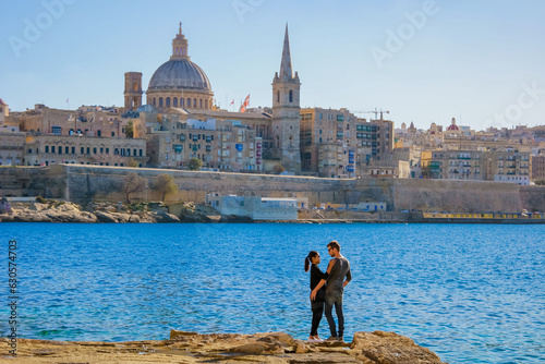 A couple on a city trip to Valletta Malta city Skyline, colorful house balcony Malta Valletta, panoramic view over Valletta Malta old town at sunset photo