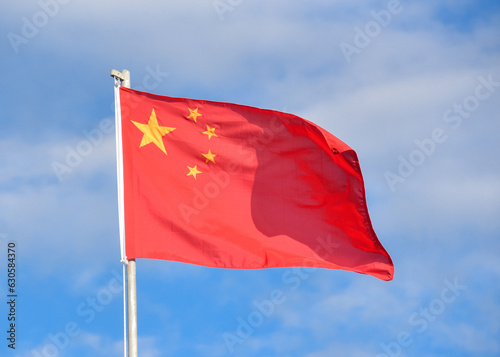 Bandera de China ondeando en el viento contra el cielo azul y nubes  